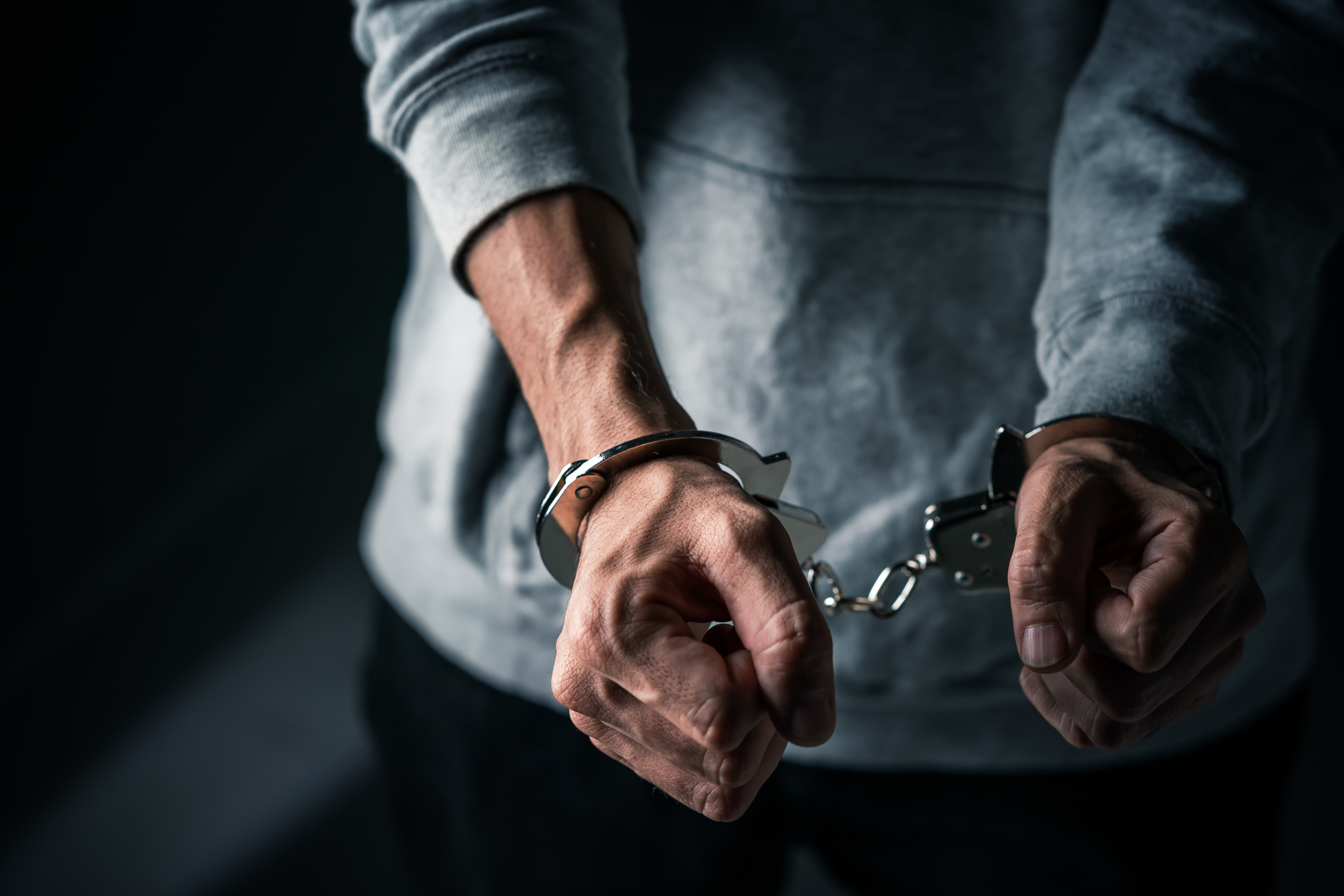An image showing a man in handcuffs.