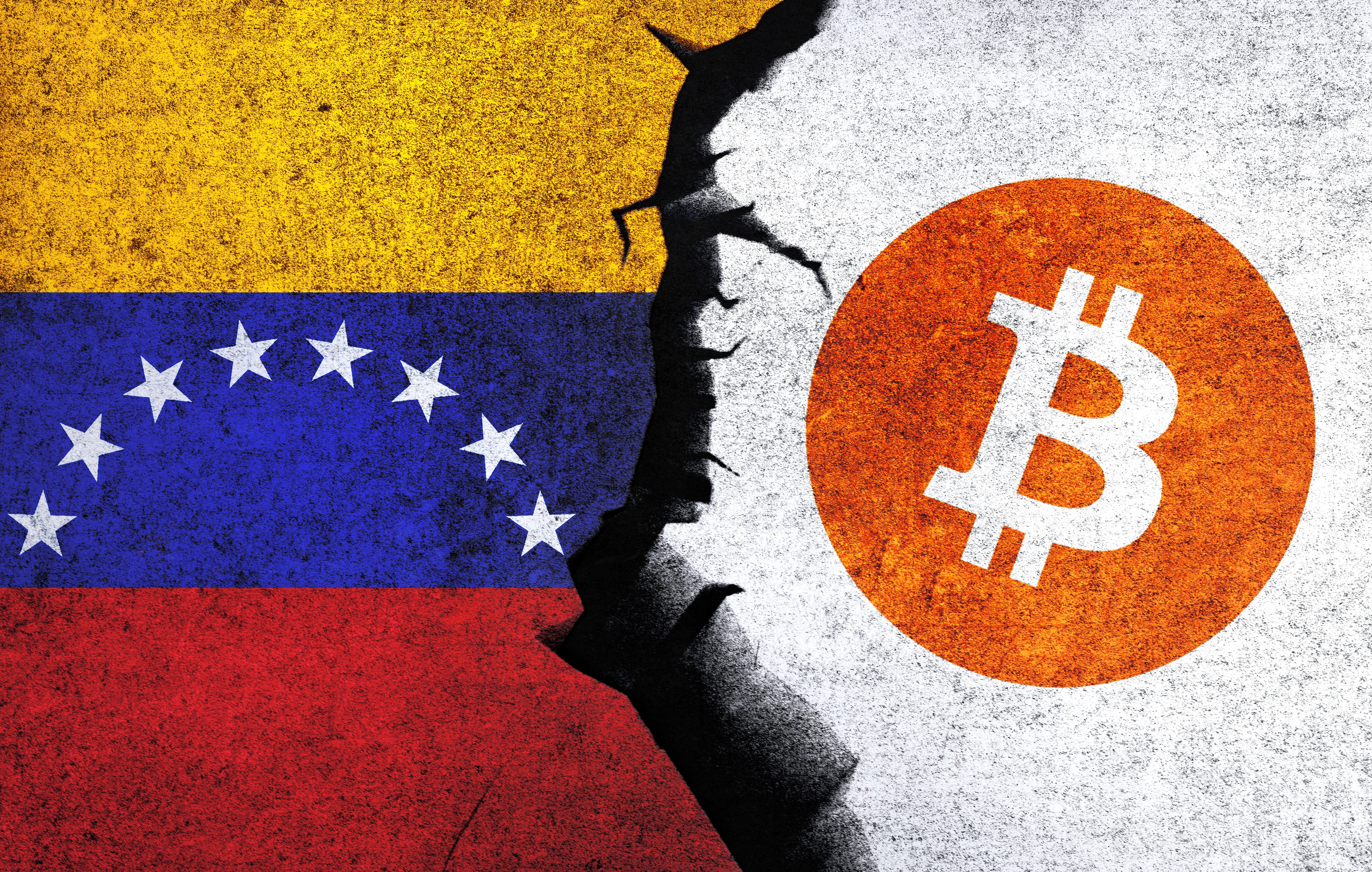 The Bitcoin logo and the Venezuela flag painted side-by-side on a wall.