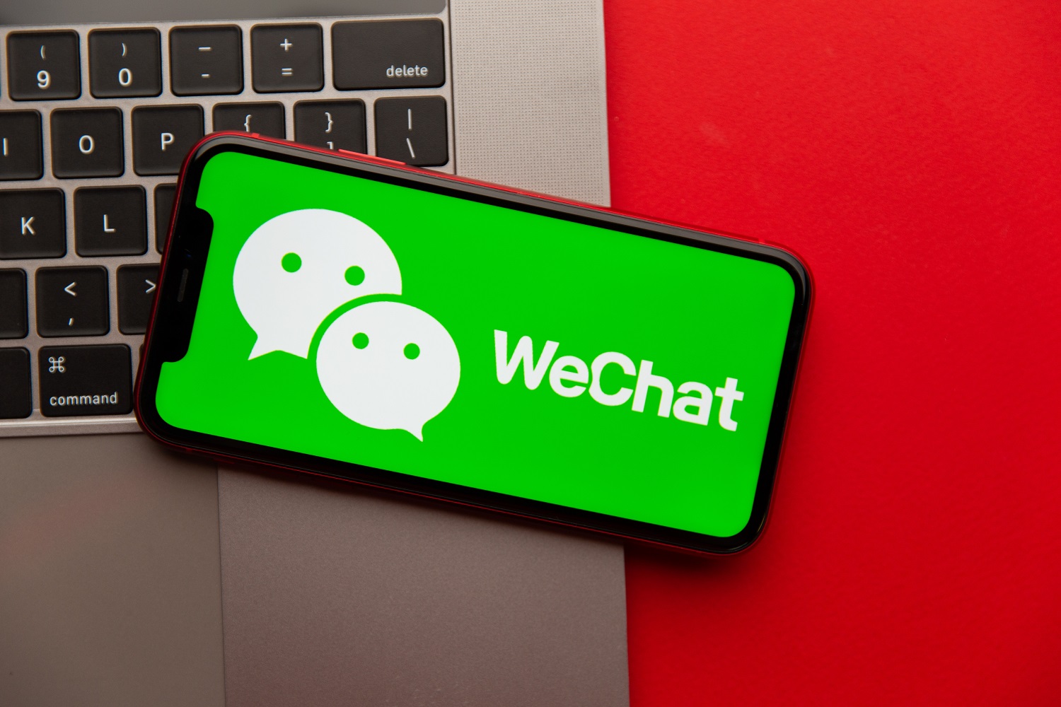 The WeChat mobile app running on the screen of a smartphone with a laptop keyboard in the background.