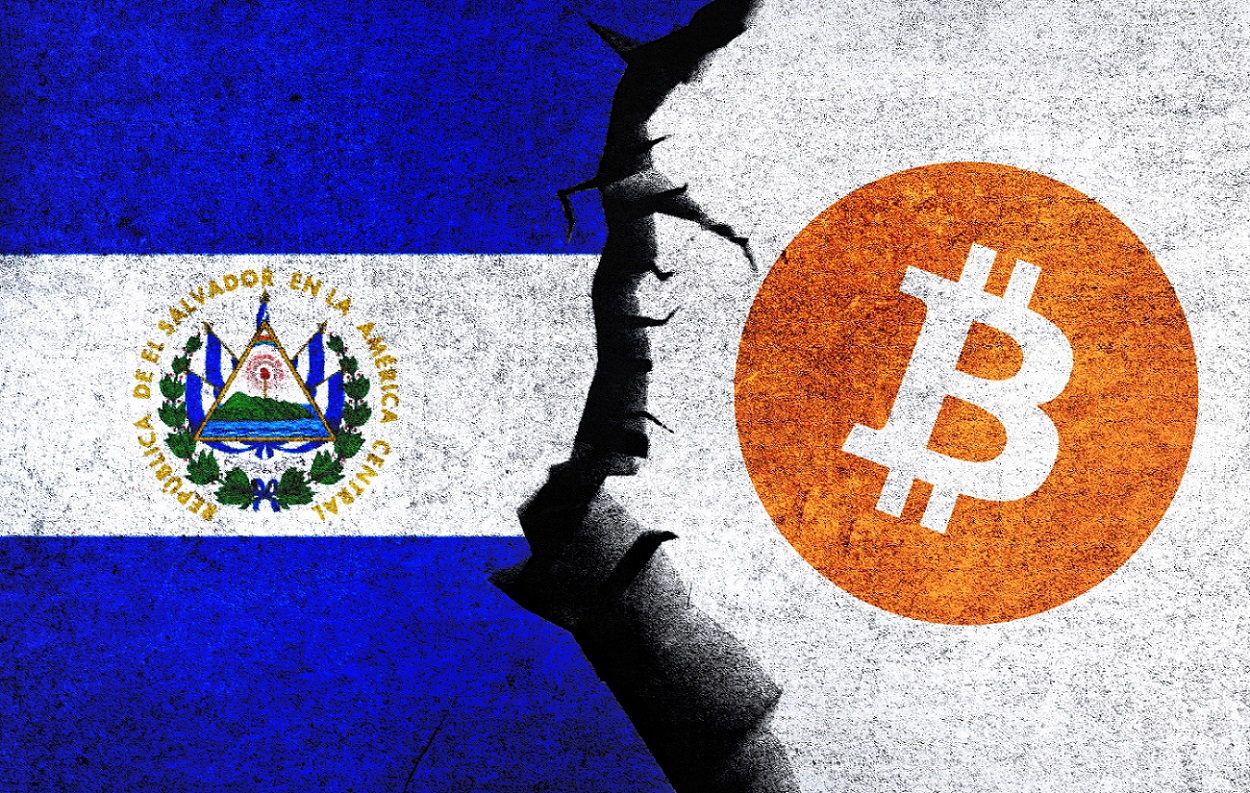 The Bitcoin logo next to the El Salvador flag on a wall with a crack between them.