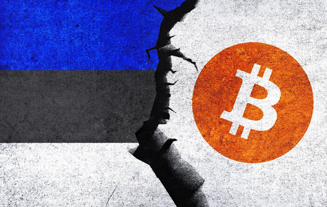 The Bitcoin symbol and the flag of Estonia are painted on a wall with a crack between them.