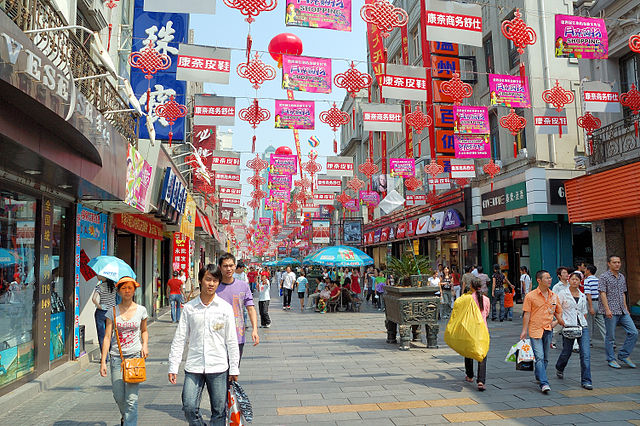 Alışveriş yapanlar, Çin'in Wenzhou kentinde kentsel bir caddede yürüyor.