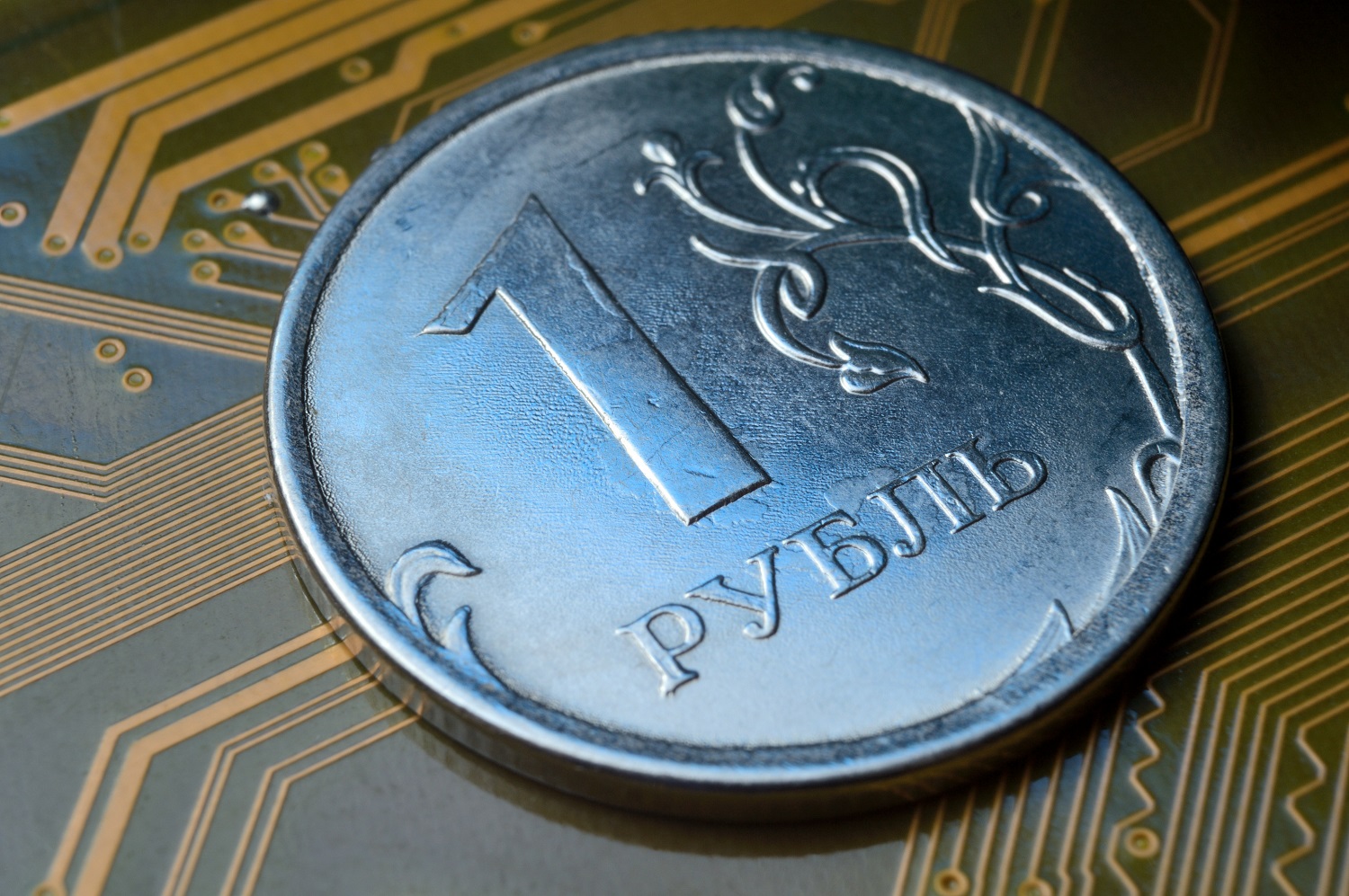 A Russian 1 ruble coin rests on an electrical circuit board.