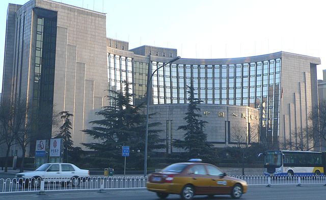 Pekin'deki Çin Merkez Halk Bankası'nın genel merkezinin önünden bir taksi geçiyor.