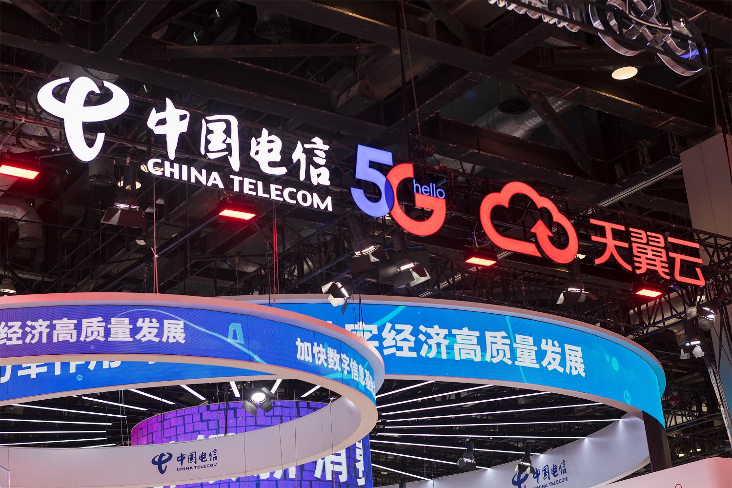 A China Telecom sign is lit up at the China National Convention Center, in Beijing, China.