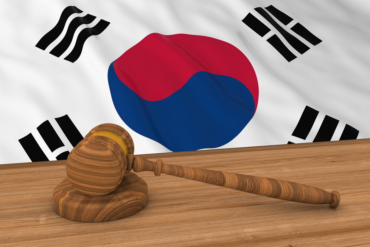 The flag of South Korea behind a wooden desk, upon which rests a gavel and block.