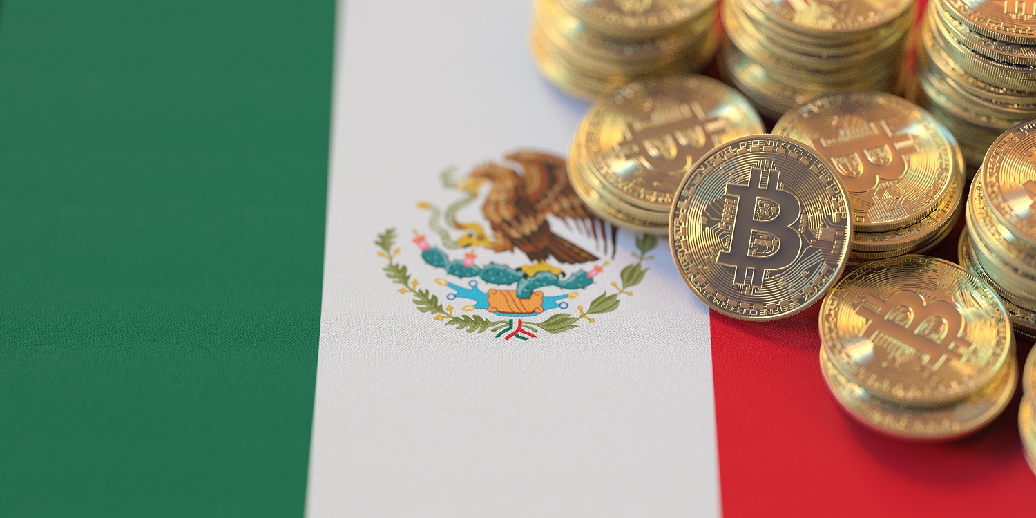 Several metal tokens intended to represent Bitcoin rest on the national flag of Mexico.