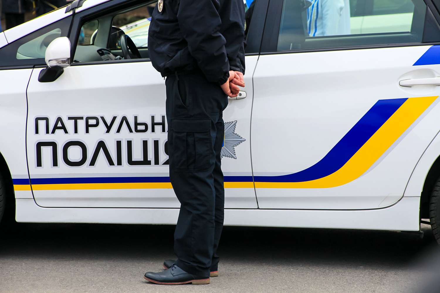 A Ukrainian policeman stands near a police patrol car.