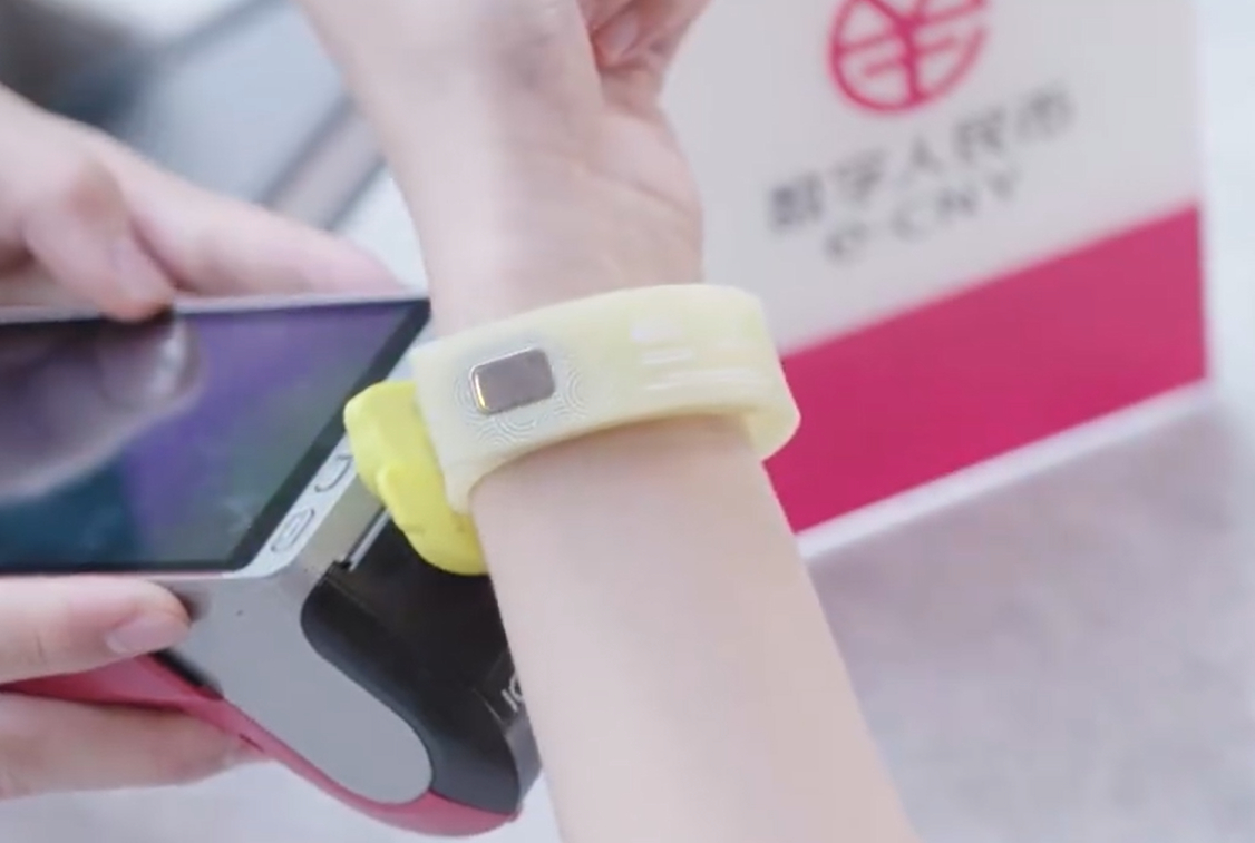 A customer uses a wearable offline “hard” digital yuan (CBDC) wallet to pay in a store.