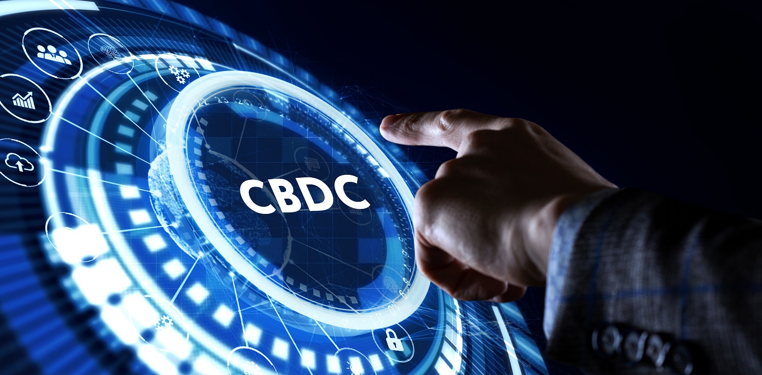 A person’s hand reaches toward a digital button marked “CBDC.”