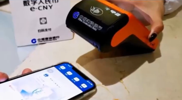 Un consumatore utilizza un portafoglio rigido digitale in yuan per pagare in un negozio su un video distribuito dalla Shanghai Pudong Development Bank.