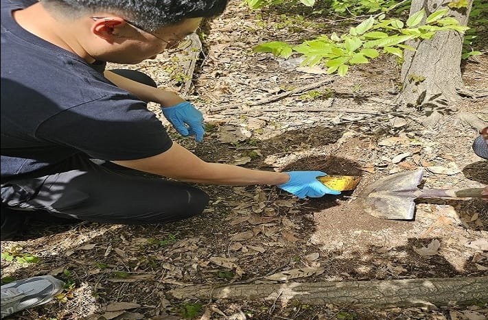 Jeonnam Provincial Police Agency officials dig up a package containing narcotics, hidden on a remote mountain path.