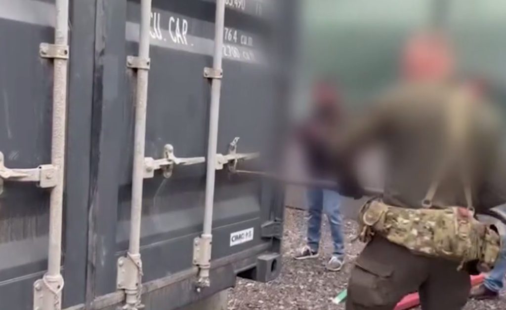Russian law enforcement officers break into a container housing hundreds of crypto mining rigs during a raid.