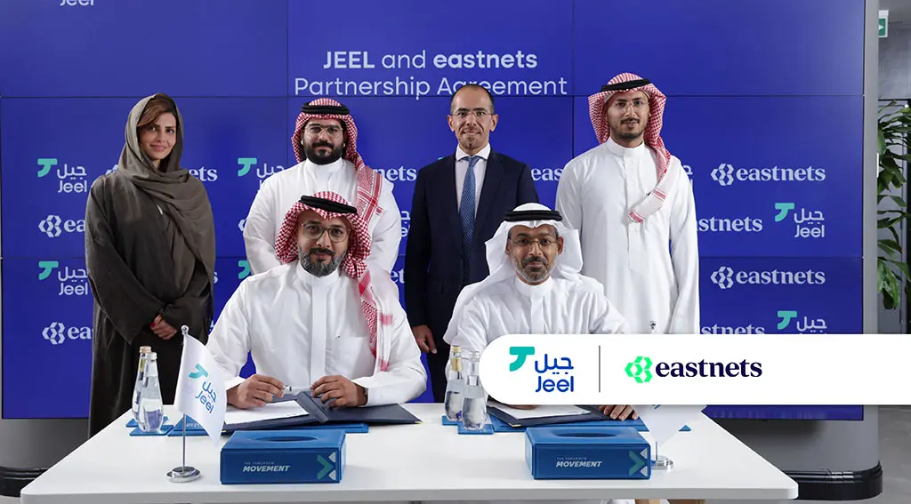 Group photo of individuals at a partnership signing event for Jeel and eastnets.