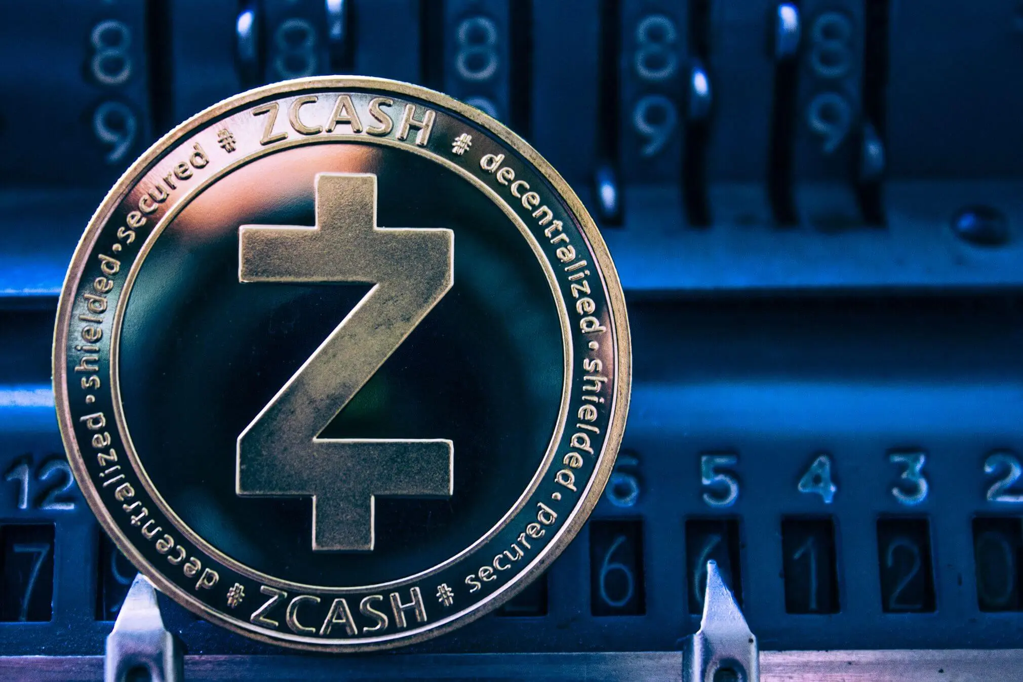 A close-up of a Zcash ZEC cryptocurrency coin against a blurred background.