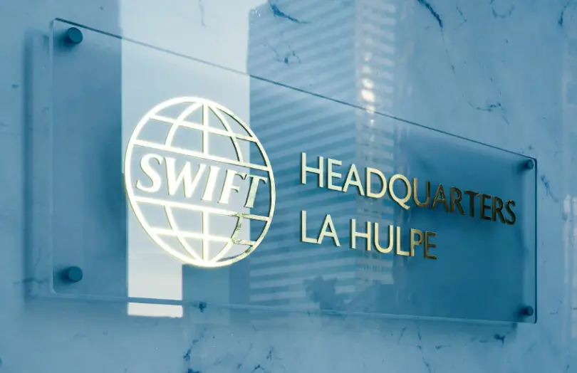 SWIFT headquarters sign displayed on a marble wall in La Hulpe.