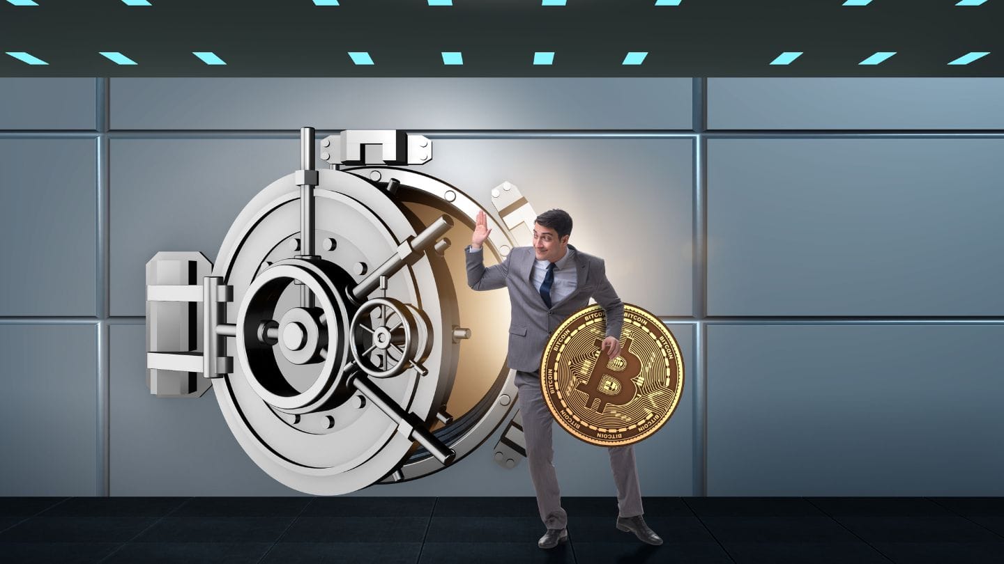 Kryptohuijaukset voivat lisääntyä. Kuvituskuvassa mies varastaa bitcoinin pankkiholvista.