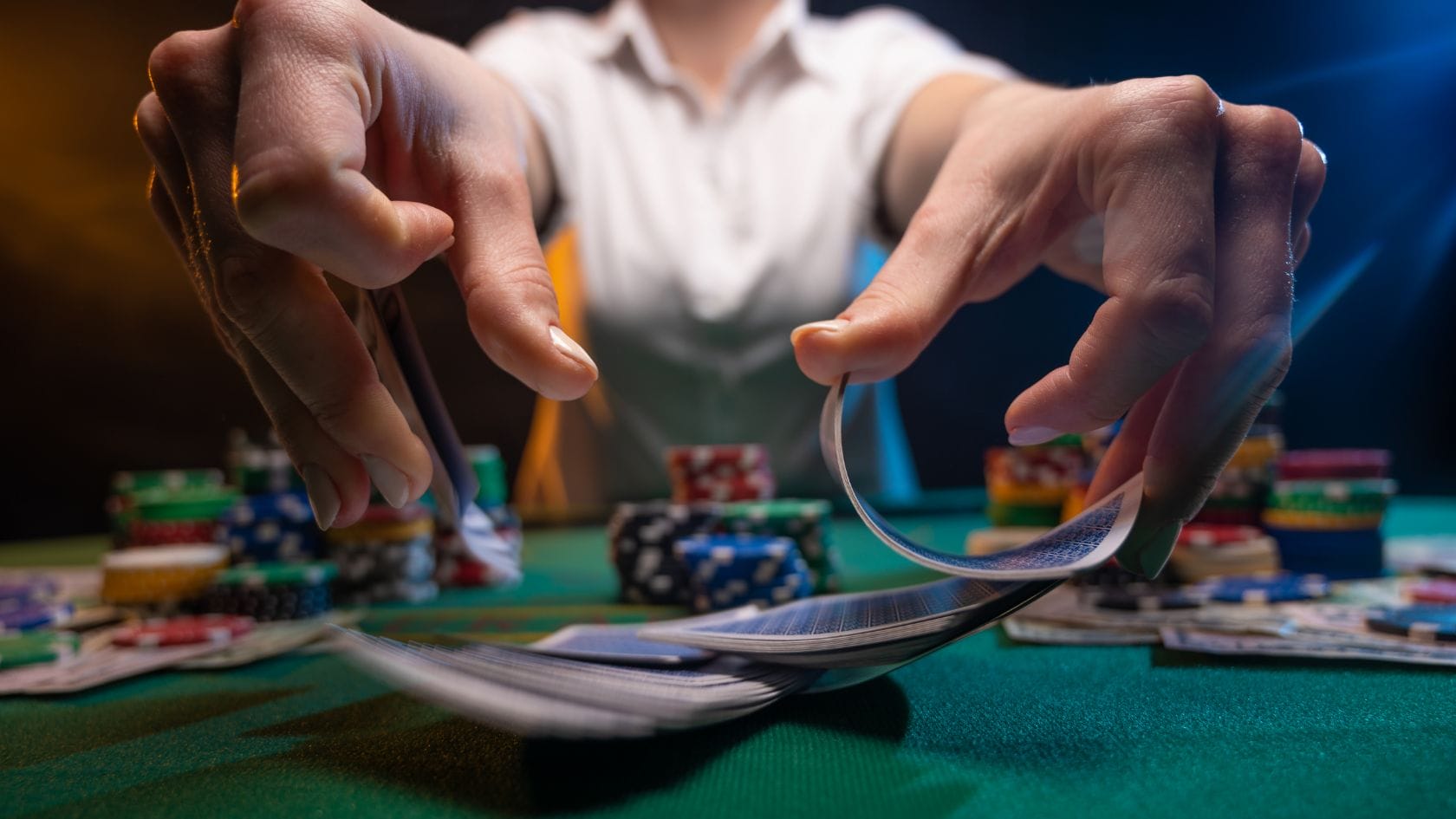 Lohkoketjuteknologia RNG -kuvituskuvassa sekoitetaan pelikortteja vihreän casinopöydän päällä.