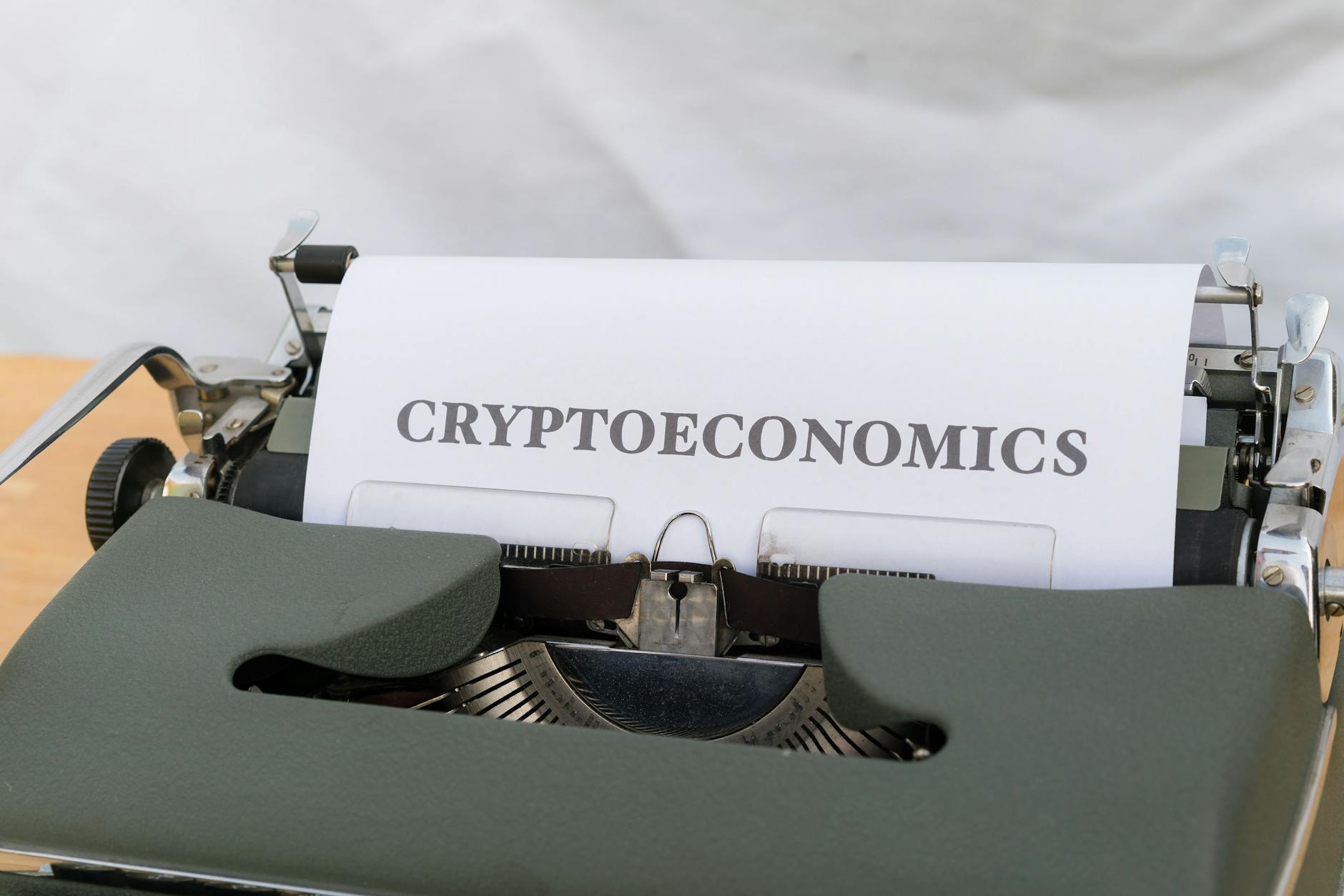 Typewriter with a sheet of paper showing the word 'CRYPTOECONOMICS'.