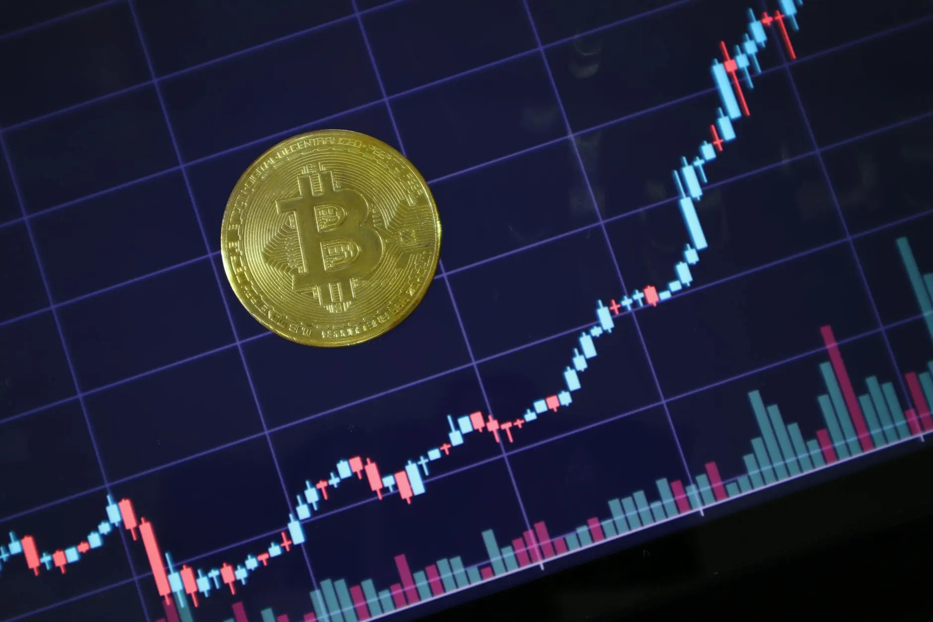 A Bitcoin coin foregrounded on a cryptocurrency trading chart with price movements.
