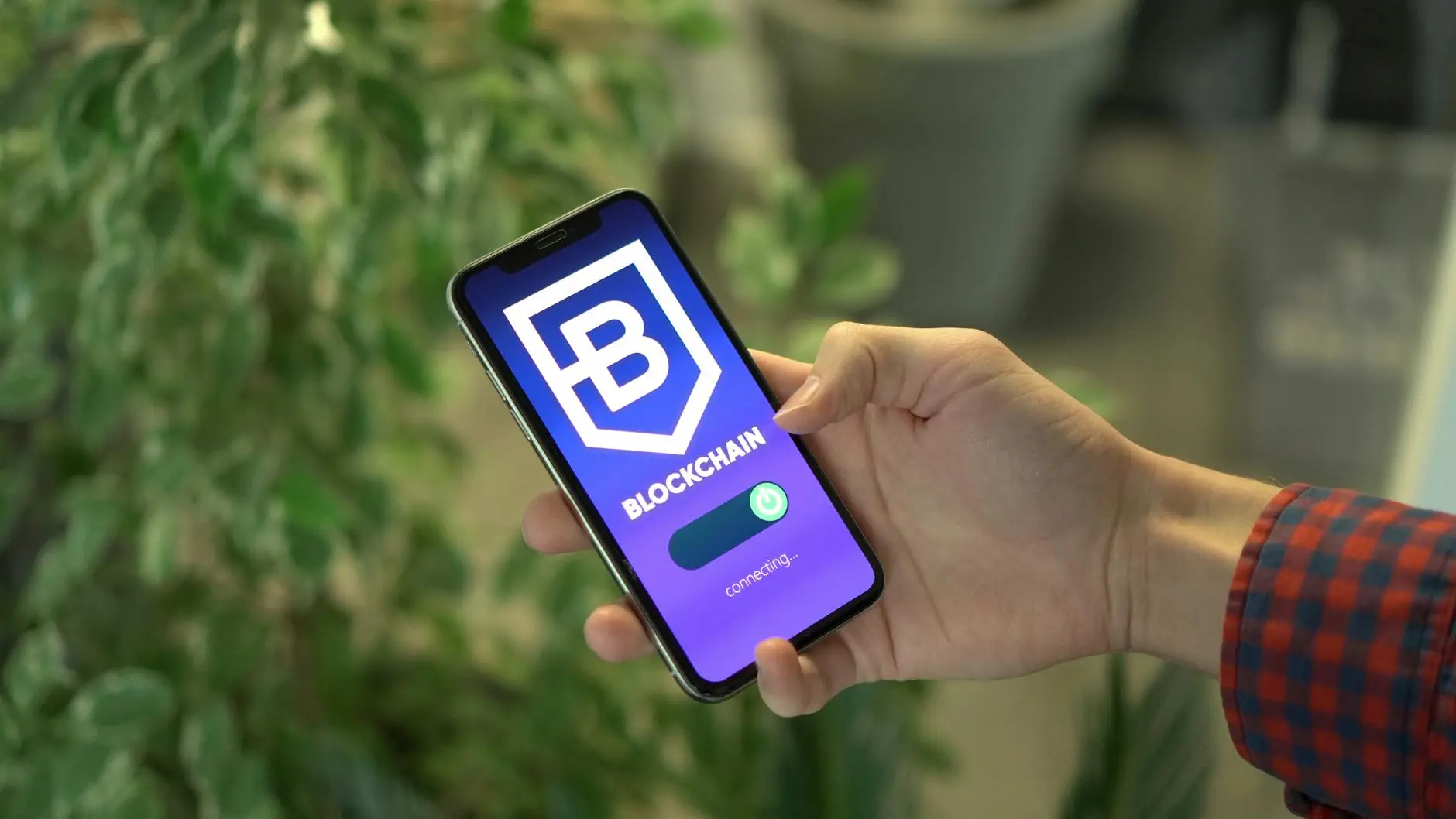 A hand holding a smartphone displaying a cryptocurrency wallet app with a connection status.