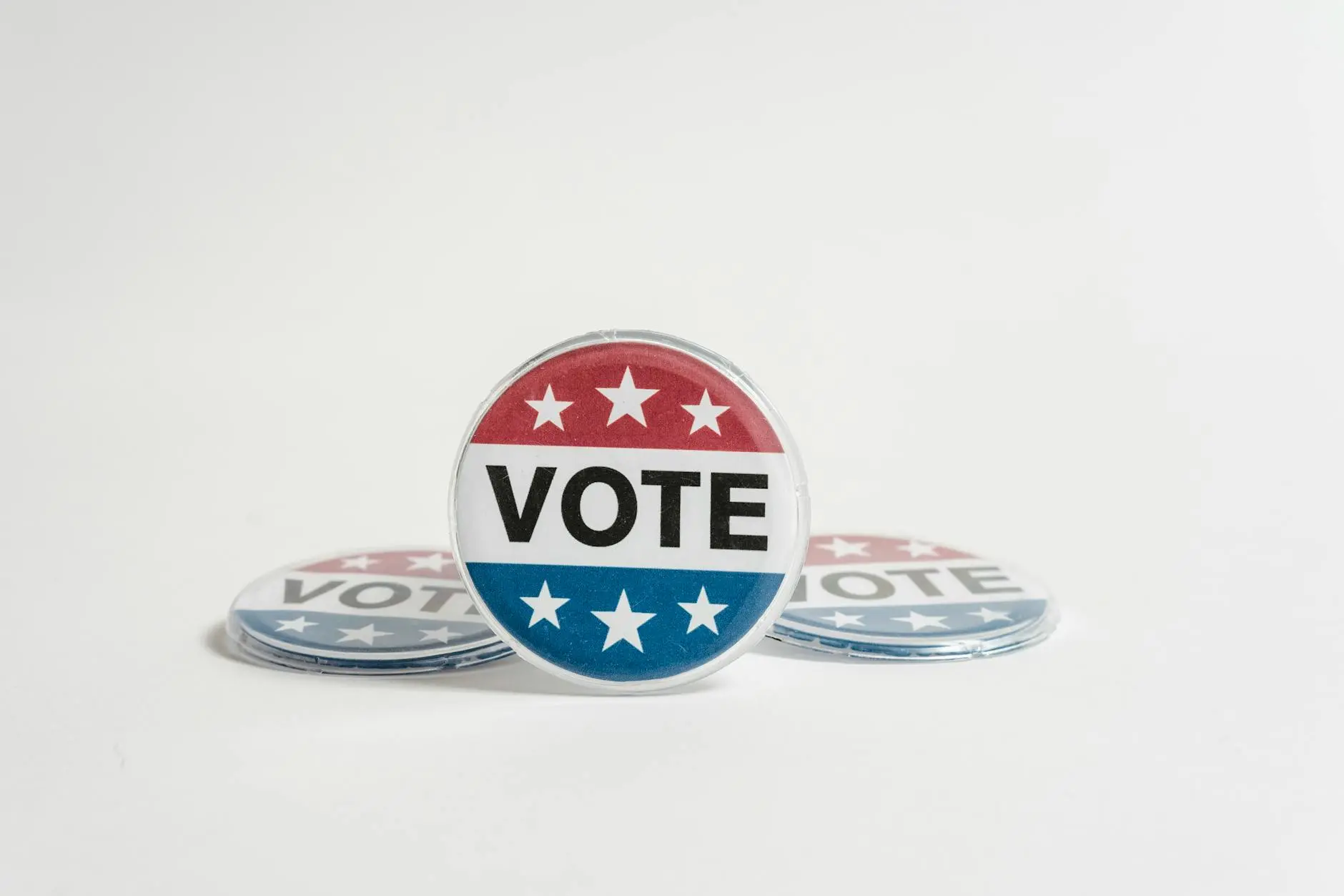 A group of colorful campaign buttons featuring the word 'VOTE' and stars.