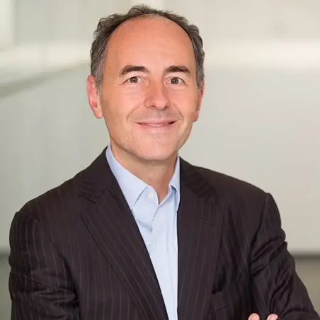 Business portrait of a man in a suit with a friendly smile in an office setting.
