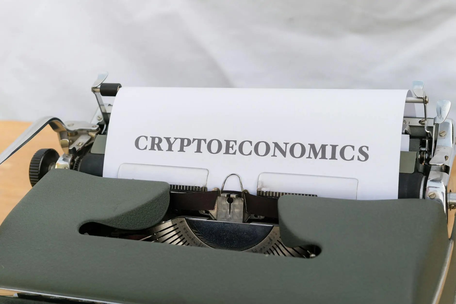 Close-up of a vintage typewriter with a paper showing the word 'CRYPTOECONOMICS'.