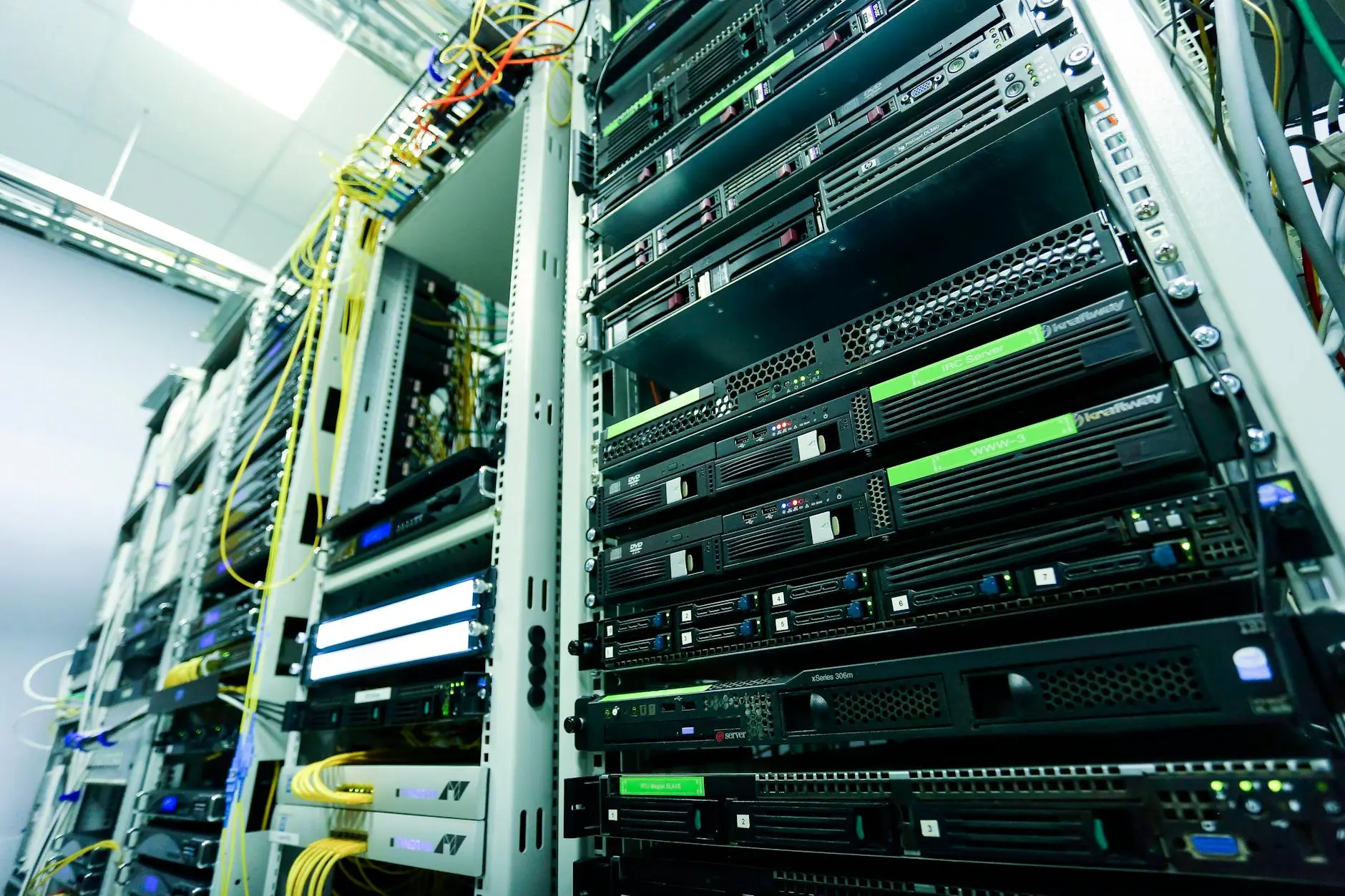 Close-up view of multiple server racks with connected cables in a data center.