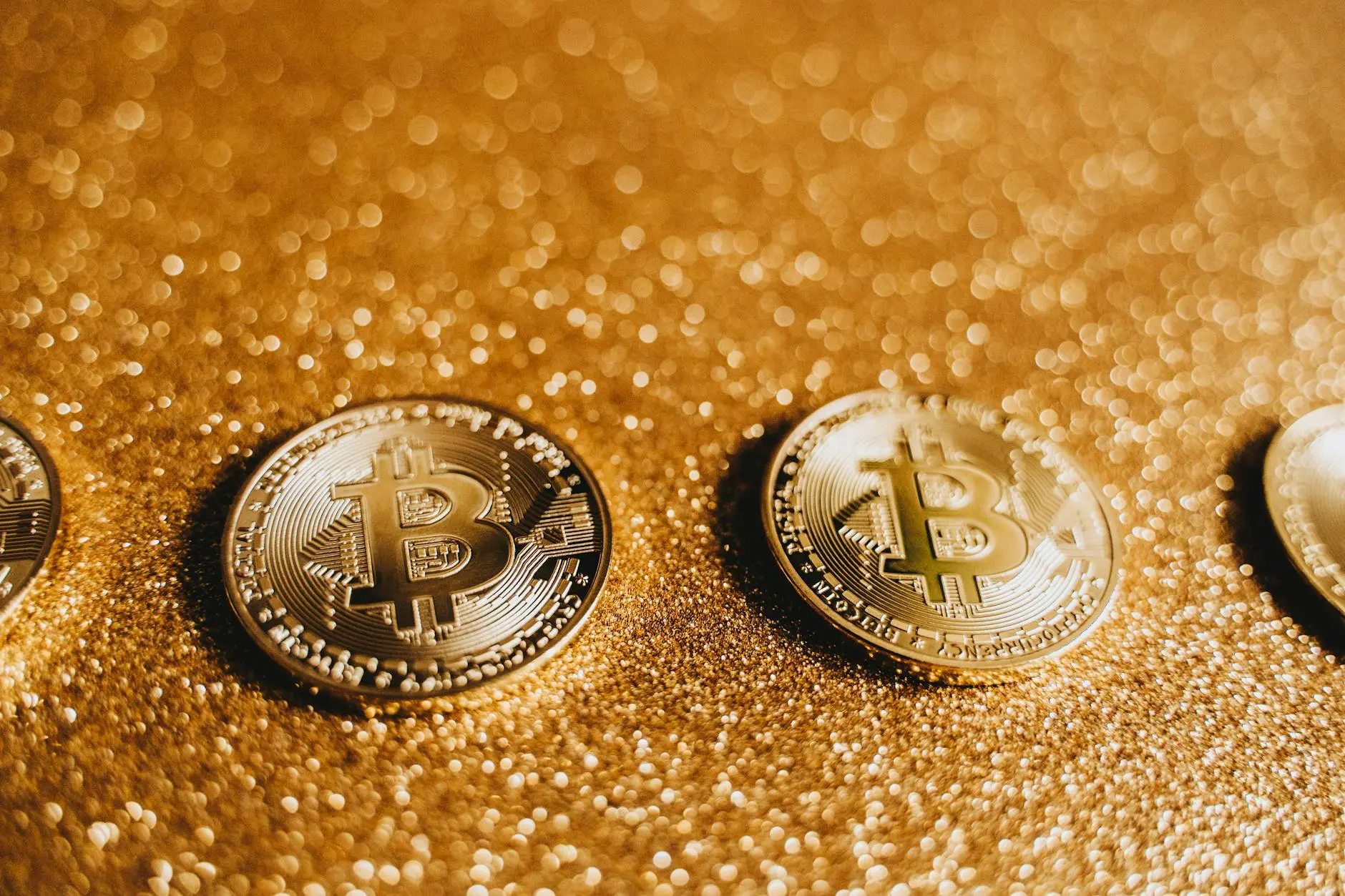 Close-up of Bitcoin coins on a sparkling gold background.