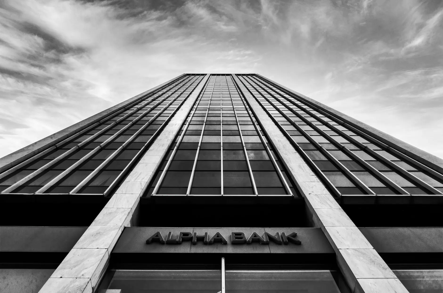 Facade of Alpha Bank building, showcasing a modern glass and stone design.