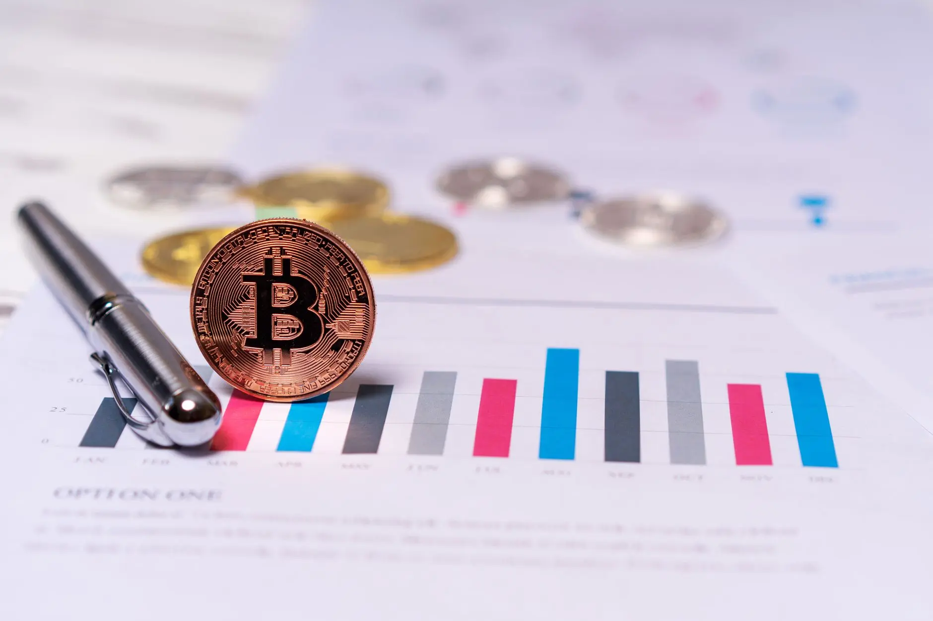 Bitcoin coin next to a financial chart with colorful bar graphs.