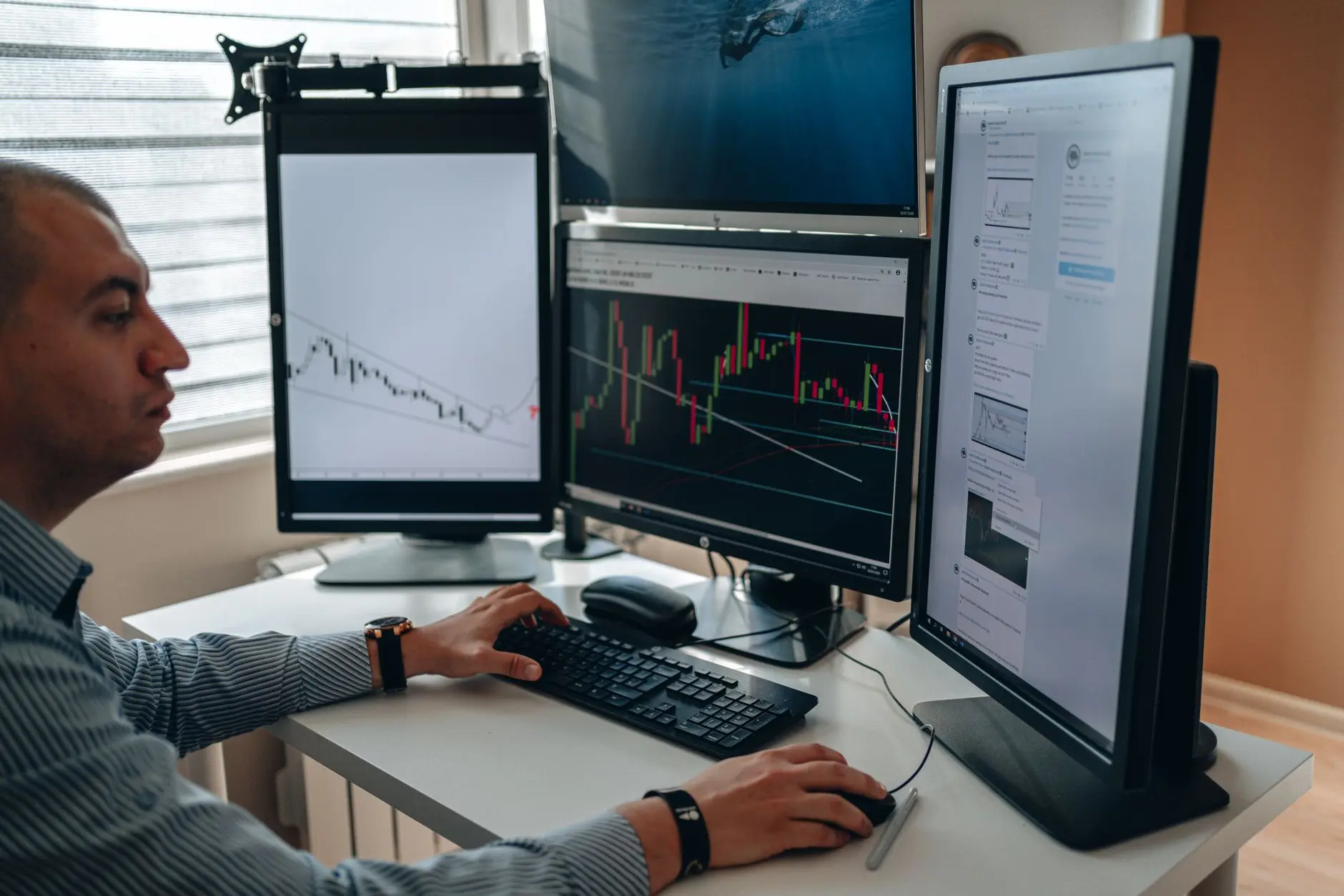 A person trading cryptocurrencies on multiple computer screens displaying charts.
