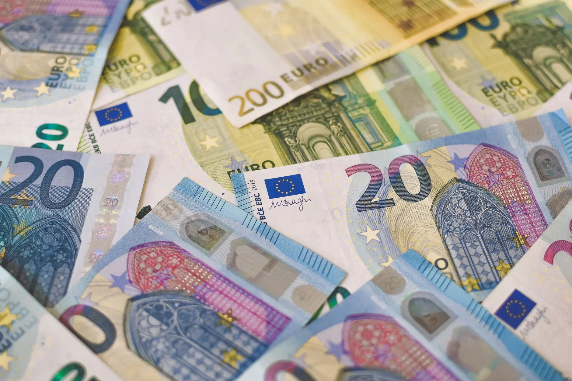 Close-up of various Euro banknotes including 20, 100, and 200 Euro bills.