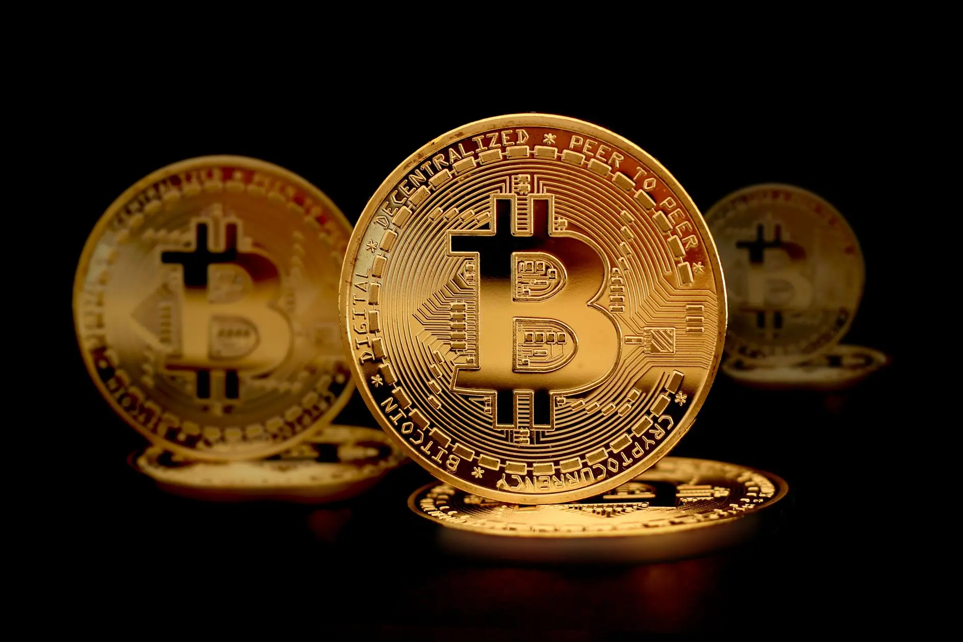 Close-up view of Bitcoin cryptocurrency tokens against a black background.