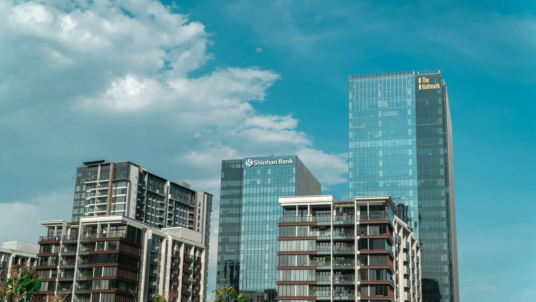 Modern skyscrapers with Shinhan Bank signage against a blue sky.