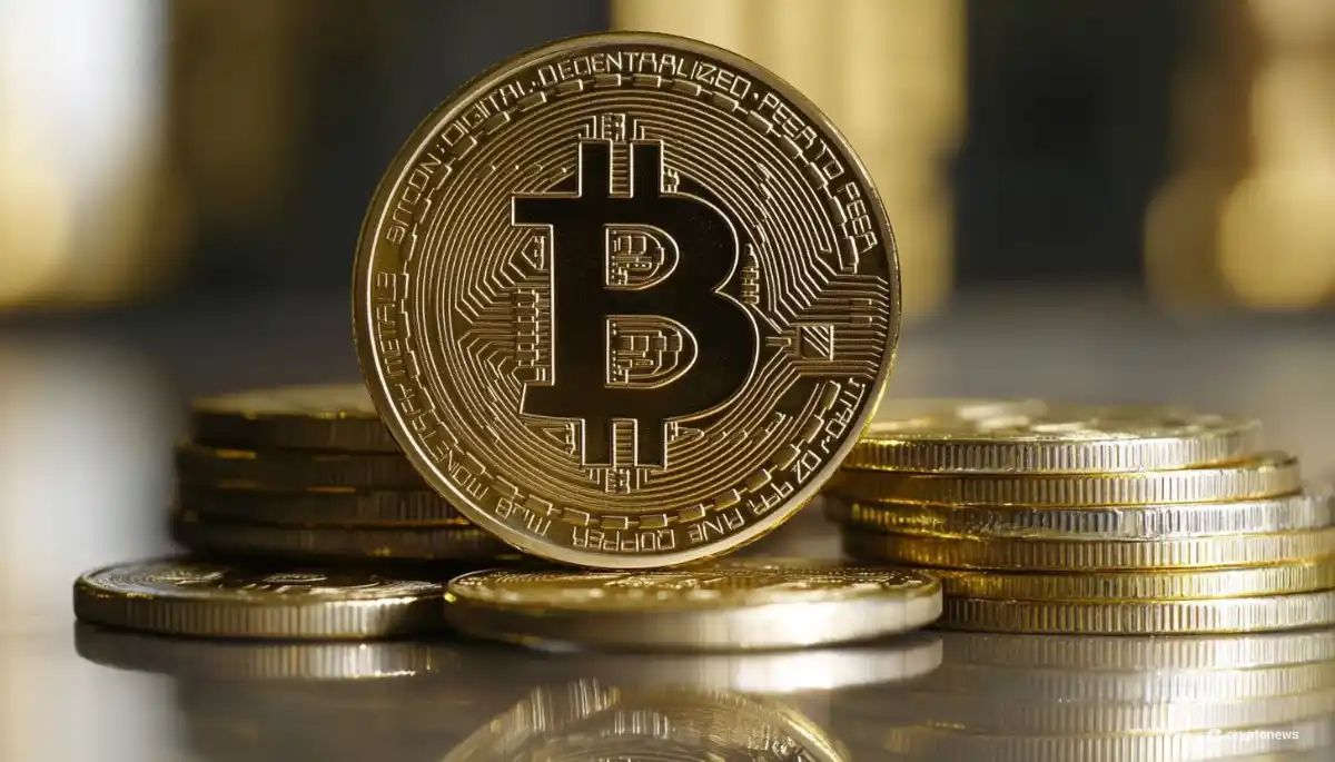 金色のビットコインコインが複数の仮想通貨コインの上に立てられており、コインの表面にはビットコインのロゴマークと回路のような模様が刻印されている。