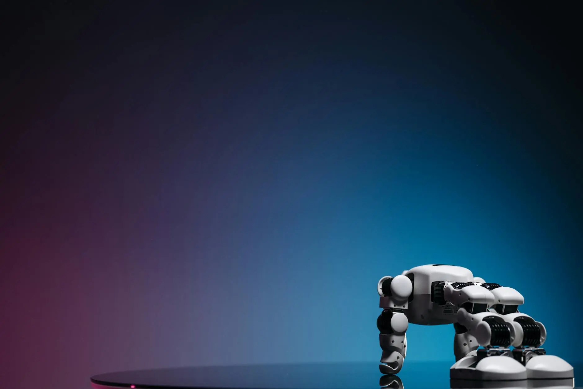 A small robot with articulated limbs on a reflective surface against a gradient background.