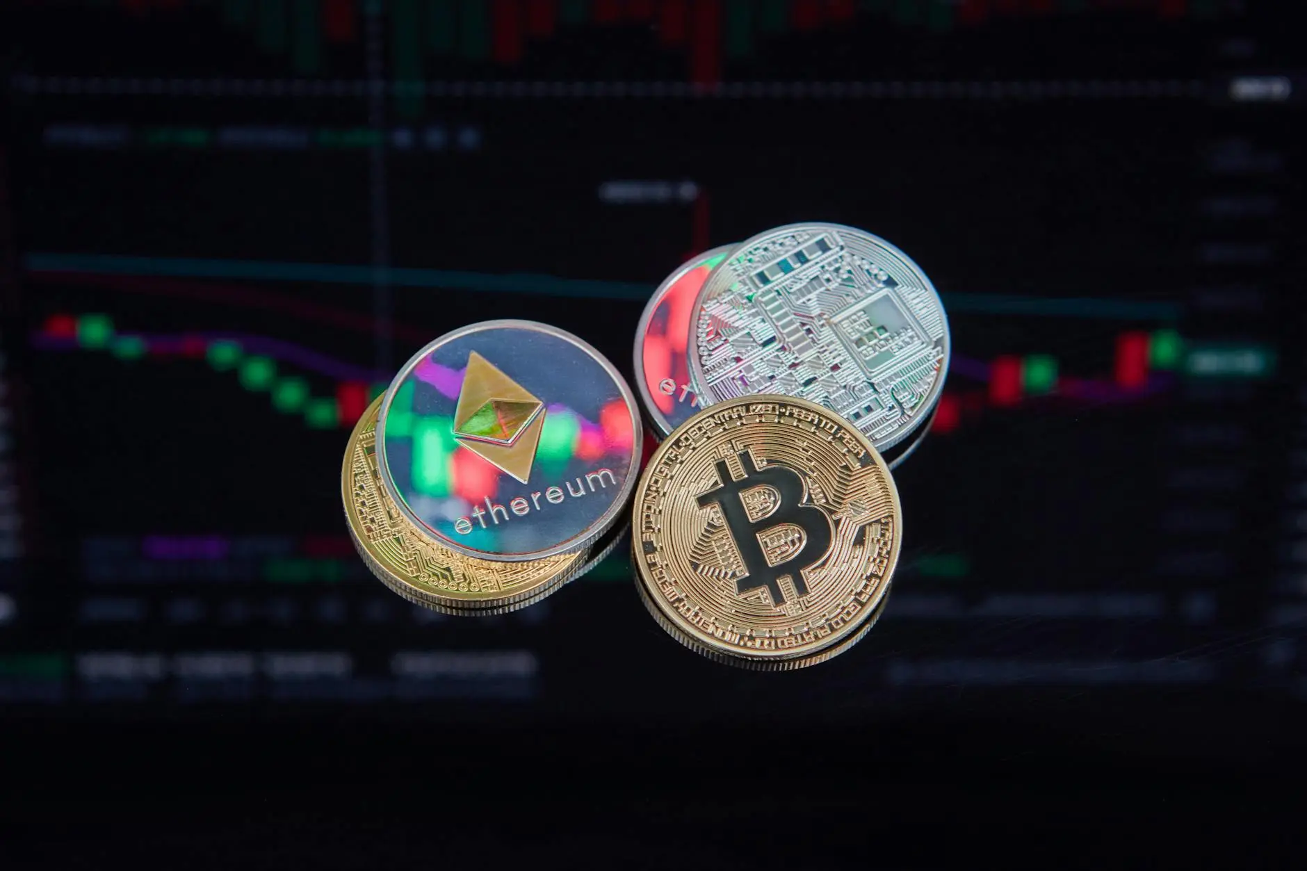 Bitcoin and Ethereum coins in front of a cryptocurrency market chart.