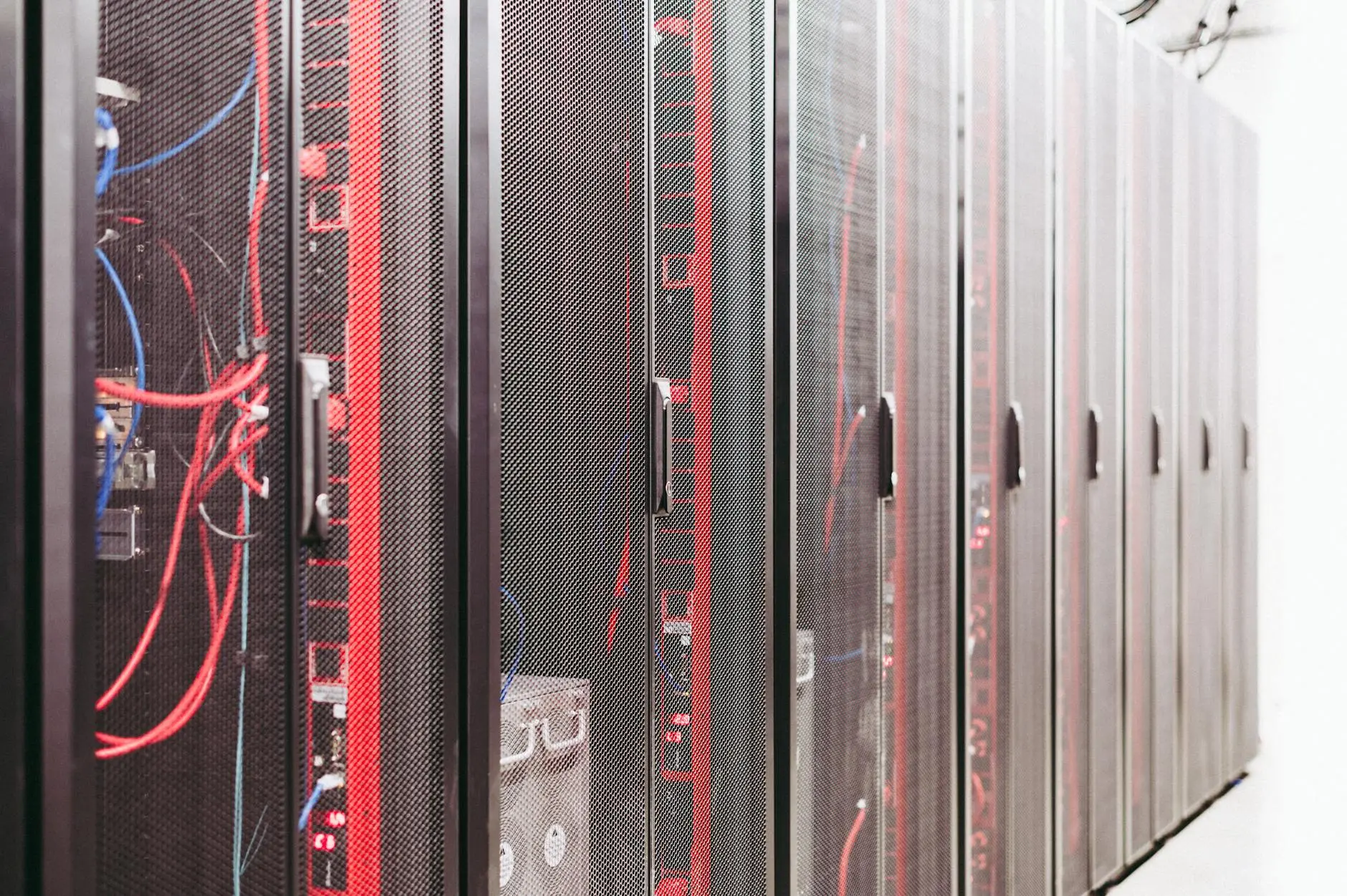 Rows of server racks with visible wiring and red lights in a data center.
