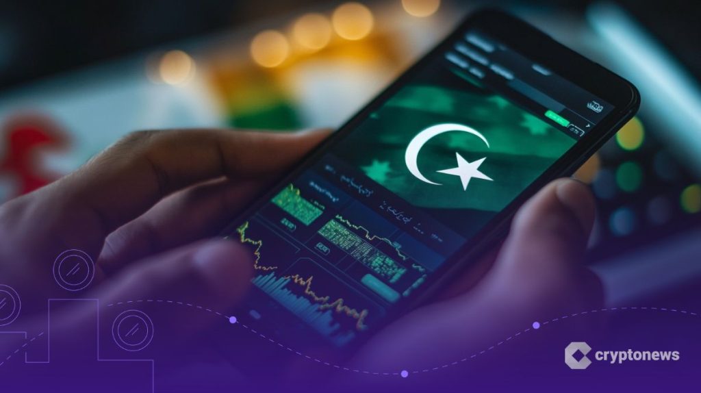 يد تمسك هاتفاً محمولاً يعرض علم باكستان وأسفله بعض بيانات التداول